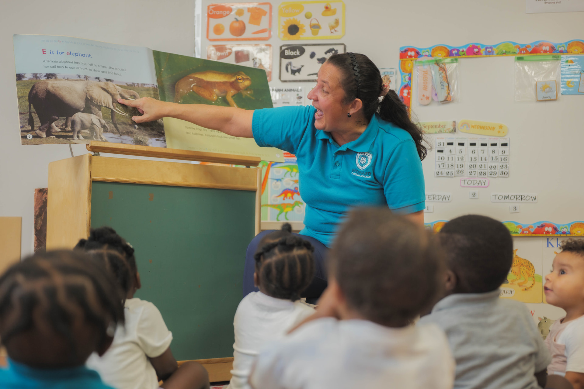 Preschool teacher reading an alphabet book to students during circle time
